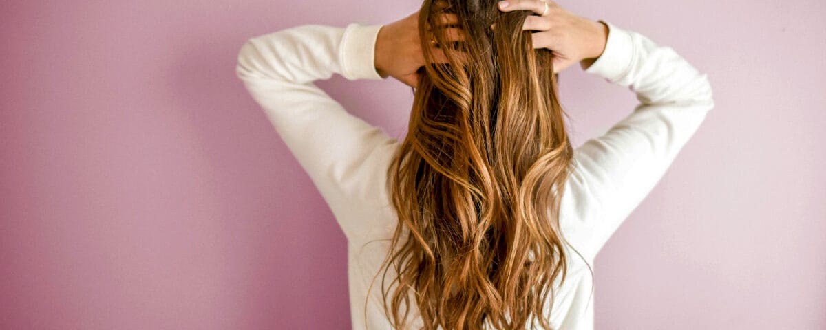 Ragazza di spalle che si tocca i capelli