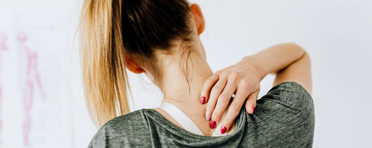 Donna che si tocca la schiena per dolore muscolare