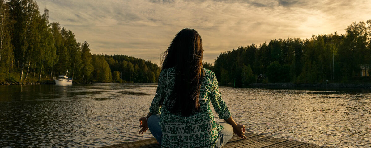 Donna che pratica yoga all'aperto al tramonto
