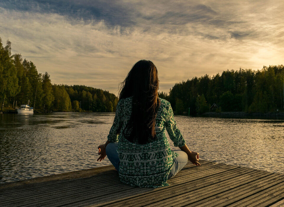 Donna che pratica yoga all'aperto al tramonto