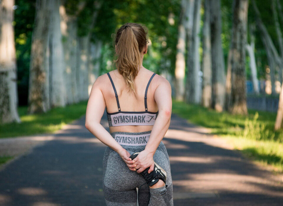 Ragazza in tenuta da corsa che fa stretching all'aperto