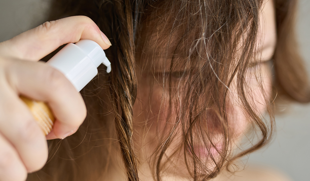 Donna che cura i suoi capelli con il balsamo